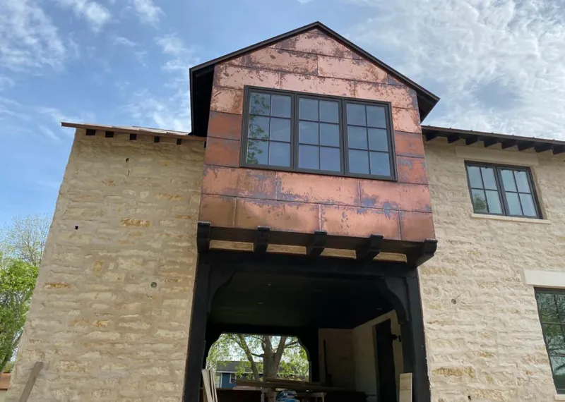 Copper metal panel facade on a stone building for Roof Repair in Merriam
