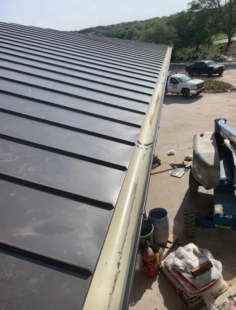 Standing seam panel and gutter detail on a metal roofing jobsite in Merriam